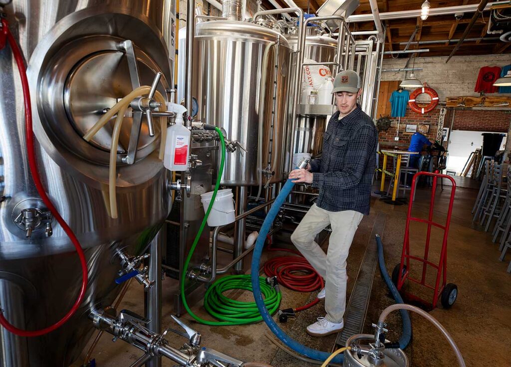 Brewer working with the tanks at Gloucester Brewing 