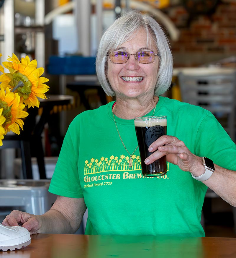 Owner Laura from Gloucester Brewing holding a beer and smiling